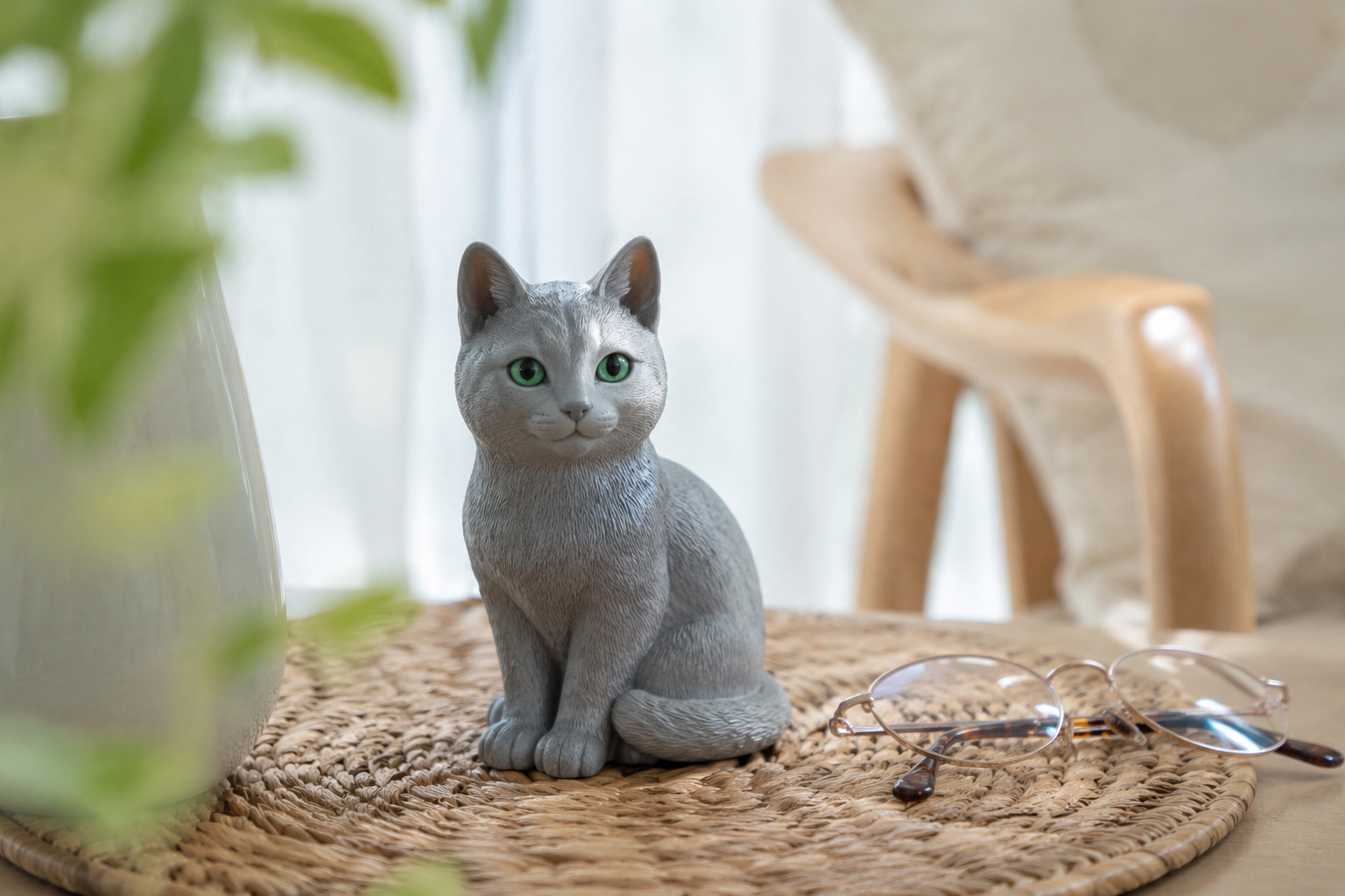 Russian Blue cat figurine sitting composed with green eyes — in-article view