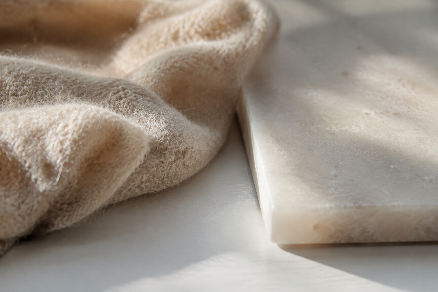 Close-up of two contrasting material textures side by side on a white surface highlighted by natural window light